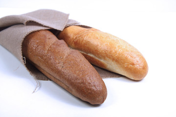 two baguettes wrapped in canvas on white background. Horizontal image