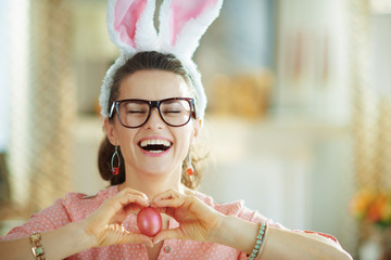 smiling modern woman with glasses showing egg