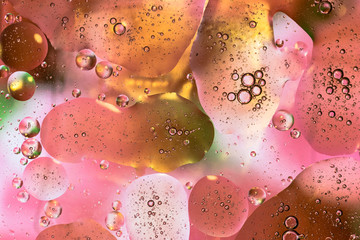 Gocce di acqua e olio su vetro e sfondo colorato 