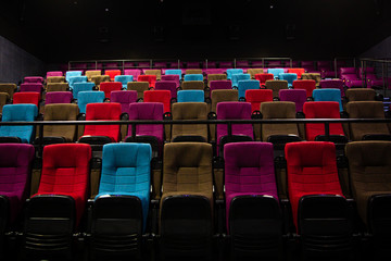 Lit empty multicolored chairs in a movie theater. Waiting for the premiere of the film