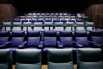 Lighted empty leather chairs in a movie theater. Waiting for the premiere of the film