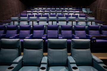 Lighted empty leather chairs in a movie theater