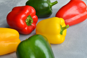 Green, red and yellow bell pepper on grey stone background. Organic healthy food. Healthy food cooking concept