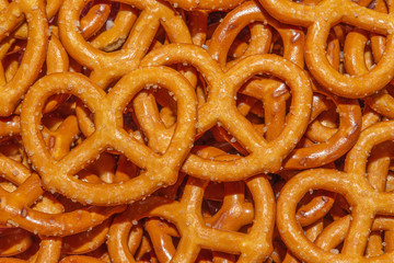 Salted Bavarian pretzel close-up, beer snack - web banner. Mini pretzel, fresh baked goods. Background or texture of fresh baked pastry. Background of pretzels.