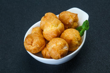 Sweet tasty profiteroles heap in the bowl
