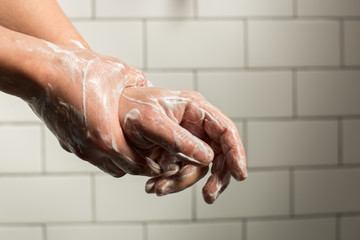 Fototapeta premium A man washing hands with soap. Preventing spreading virus concept.