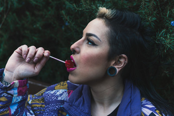 Chica chupando un caramelo sentada en un banco