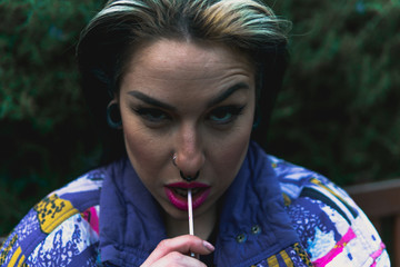 Chica chupando un caramelo sentada en un banco