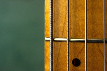 Section of bass guitar fretboard and strings extreme close up.