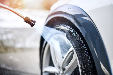 Car wheel wash. Car cleaning with water jet. Car rim or aloy washing close up.