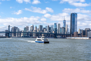 Manhattan Bridge shot from the water on a ferry with manhattan wall street behind new york city nyc USA