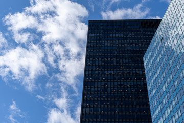 Reflections of the clouds on a glass skyscraper in new york city, scenic view from below