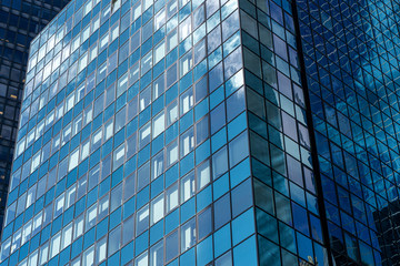 Fototapeta na wymiar Reflections of the clouds on a glass skyscraper in new york city, scenic view from below