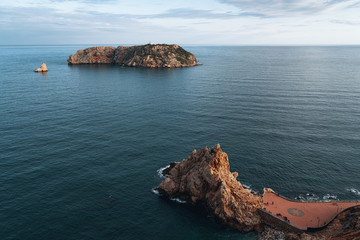 Scenic view of remote island with lighthouse