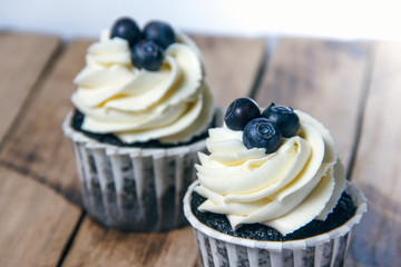 Homemade chocolate cupcakes on a background of wooden boards. Homemade baking.
