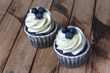 Homemade chocolate cupcakes on a background of wooden boards. Homemade baking.