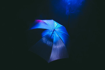 umbrella on black background , blue and red smoke