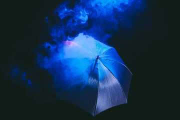 umbrella on black background , blue and red smoke