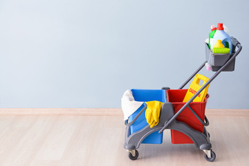 Set of cleaning supplies near color wall