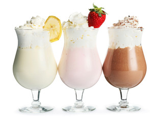 Glasses of tasty milkshakes on white background
