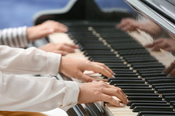 Obraz premium Private music teacher giving piano lessons to little boy, closeup