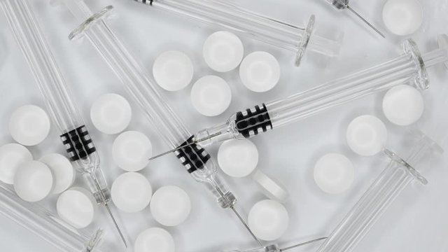 Top View Rotating Of Syringes and Medical Pills and Drugs Close-up .