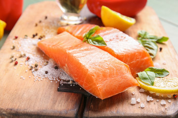Raw salmon fillet with spices on table