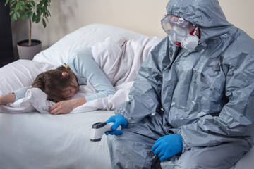 Chora nieprzytomna kobieta leży w łóżku z zamkniętymi oczami. Osoba ubrana w kombinezon ochronny i maskę siedzi na łóżku ze spuszczoną głową. W ręce trzyma termometr. - obrazy, fototapety, plakaty