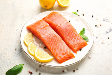 Raw salmon fillet with spices and lemon on white background