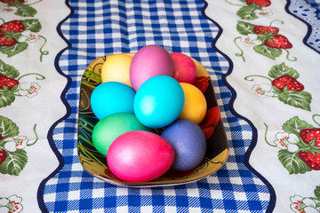 Bright easter eggs in a saucer on the festive table