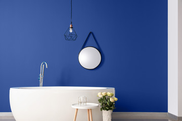 Interior of modern bathroom with blue wall