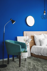 Interior of modern bedroom with blue wall