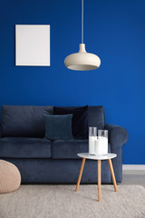 Interior of modern living room with soft couch near blue wall
