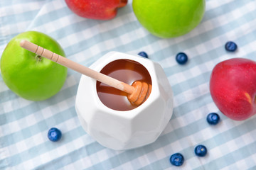 Tasty honey with fruits on table
