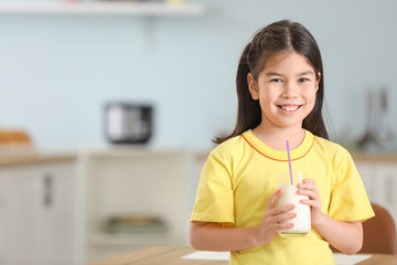 Cute Asian girl with milk at home