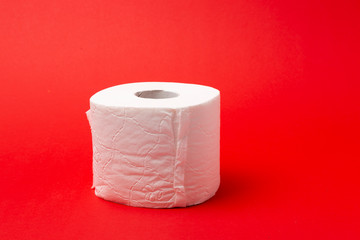 Symbol image for corona crisis panic buying / hoarding. Roll of toilet paper on red Background,...
