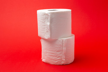 Symbol image for corona crisis panic buying / hoarding. Pile of toilet paper on red Background,...