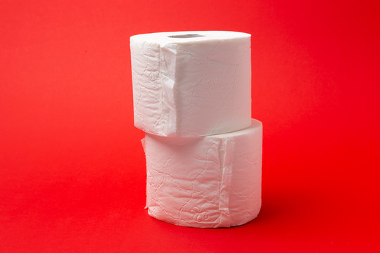 Symbol image for corona crisis panic buying / hoarding. Pile of toilet paper on red Background, with copy space.