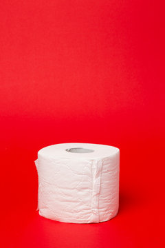 Symbol image for corona crisis panic buying / hoarding. Roll of toilet paper on red Background, with copy space.
