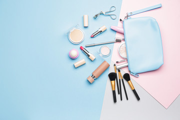 Bag with makeup accessories and decorative cosmetics on color background