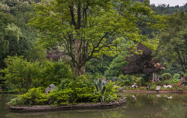 Gardeners behind and islet in pond in Seven Star Park, Guilin, China.