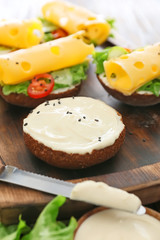 Fresh bun with tasty cream cheese and sandwiches on board