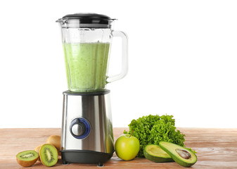 Blender with ingredients for healthy smoothie on table against white background
