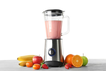 Blender with ingredients for healthy smoothie on table against white background