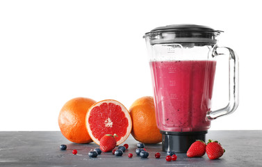 Blender with ingredients for healthy smoothie on table against white background