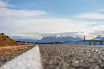 Asphalt road with snowy mountains in the background in Mount Cook, New Zealand