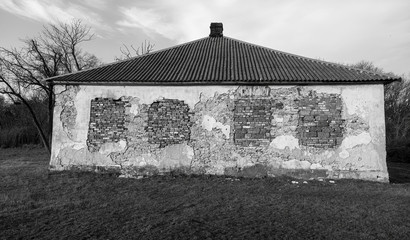 Old abandoned building with ruined windows and walls. Huge large cracks in old brick wall. Abandoned house not needed. Devastation after earthquake. Apocalypse