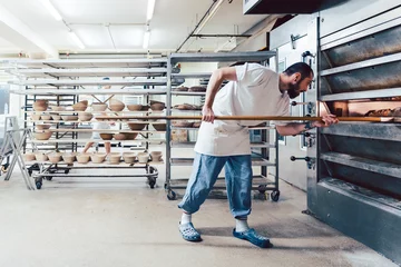 Gordijnen Bakker controleert brood in de bakkersoven © Kzenon