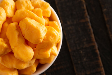 Bowl of Cheddar Cheese Curds on a Rustic Wooden Table