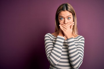 Young beautiful blonde woman wearing casual striped shirt over purple isolated background shocked covering mouth with hands for mistake. Secret concept.